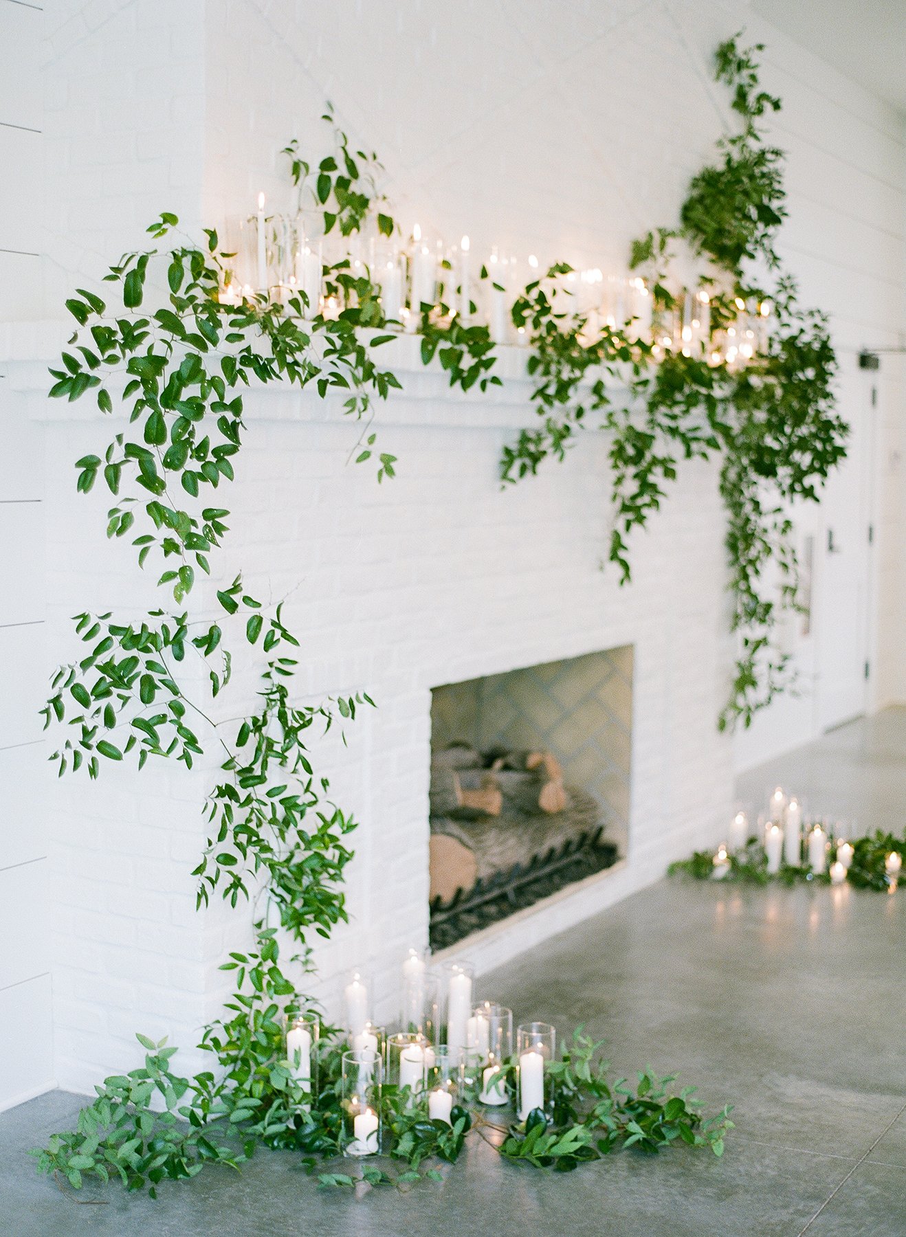 greenery garland on white mantle with candles