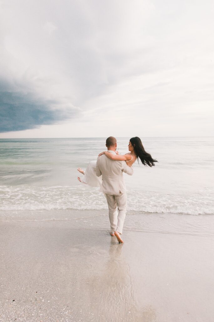 destination wedding couple walking into the ocean 