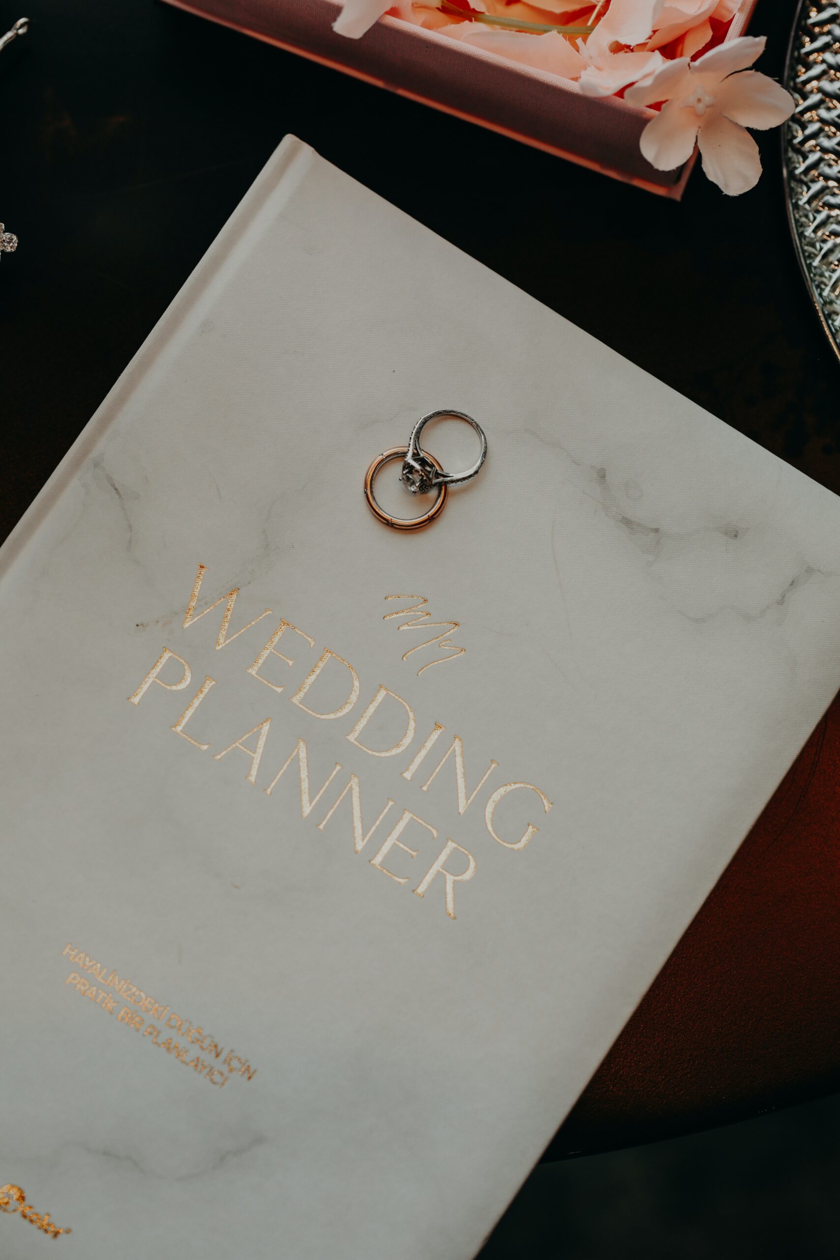 Engagement rings sitting on top of wedding planner binder