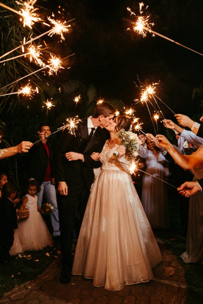 wedding couple kissing after ceremony under sparklers 