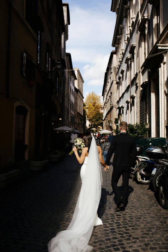 Destination Wedding Trends 2024: wedding couple walking through European city aft their ceremony 